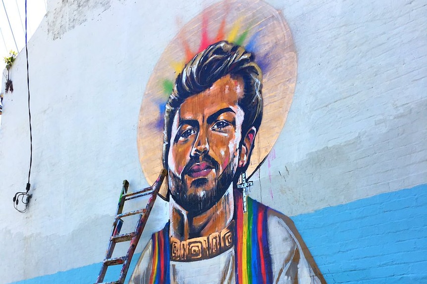 A mural on a house depicts singer George Michael as a saint with a rainbow halo.