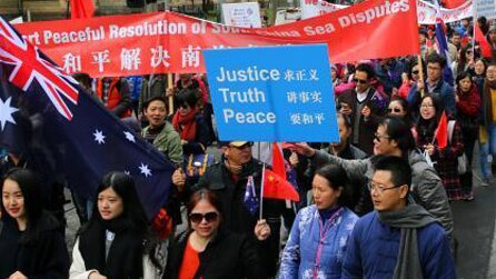 People hold signs at a pro-China protest in Melbourne.