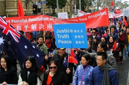 People hold signs at a pro-China protest in Melbourne.