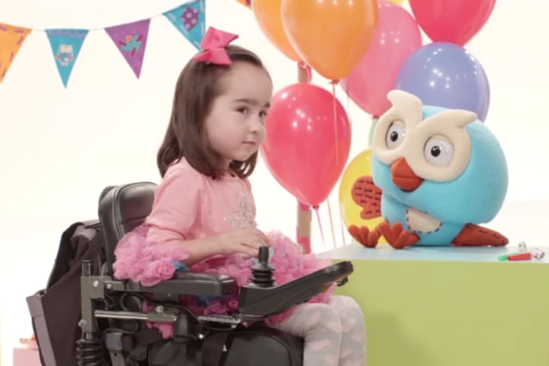 Isabella Lombardo in her wheelchair next to Hoot the owl.