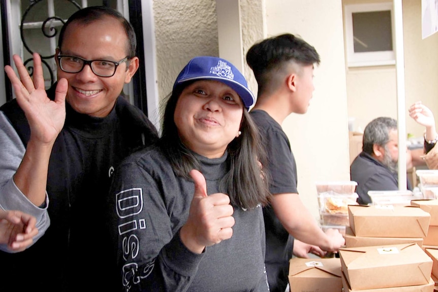 Two people waving to the camera.