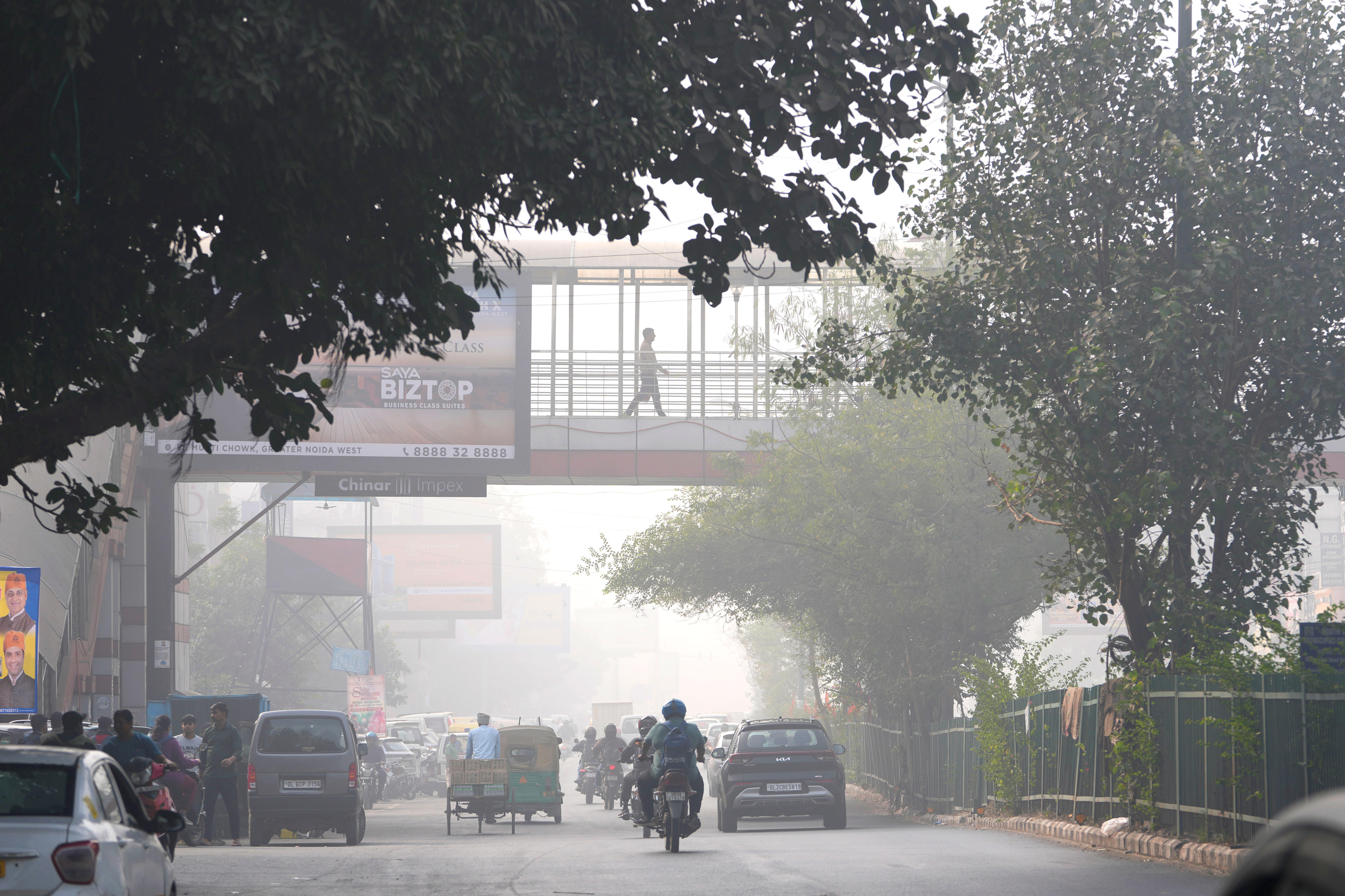 Commuters drive through a thick layer of smog early in the morning in Delhi