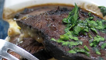 cooked beef cheeks in a bowls with parsley on top