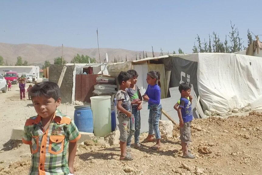 Children huddle near makeshift tents in beirut