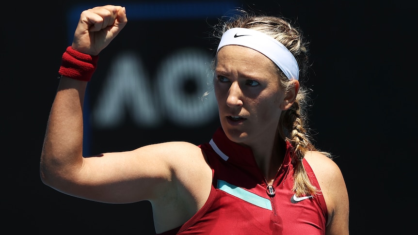 A female teniis players pups her fist after winning an Australian Open match.
