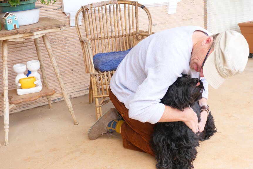 A man cuddles his dog.