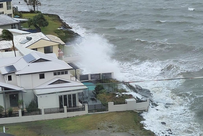 Water sprays over the fences of waterfront homes