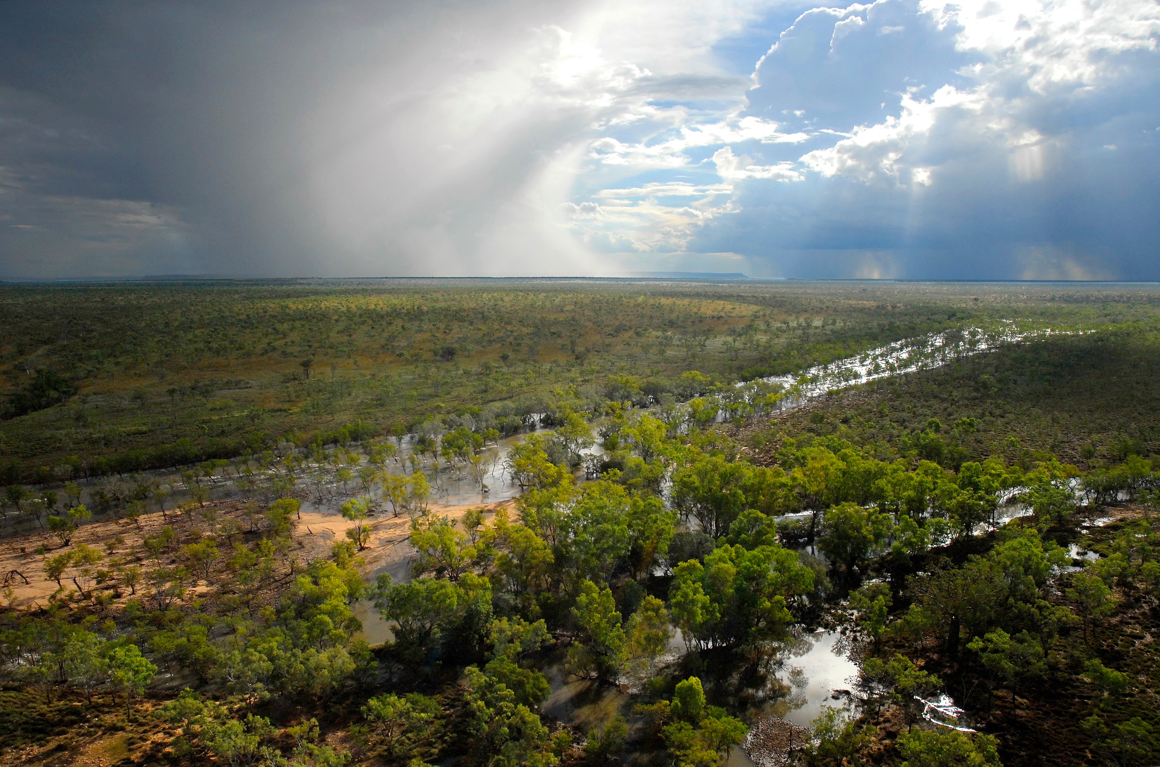 A storm front passes over a floodplain.