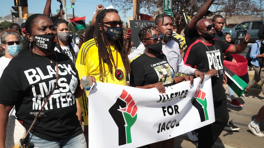 Family of Jacob Blake lead a protest wearing masks saying Justice for Jacob Blaks and black lives matter t-shirts