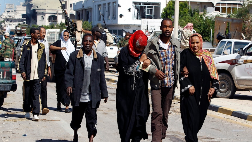 Civilians walk the streets of Sirte