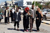 Civilians walk the streets of Sirte