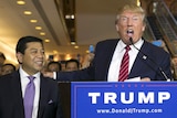 Donald Trump yells into a microphone with his hand on Setya Novanto's shoulder during an election event in New York.