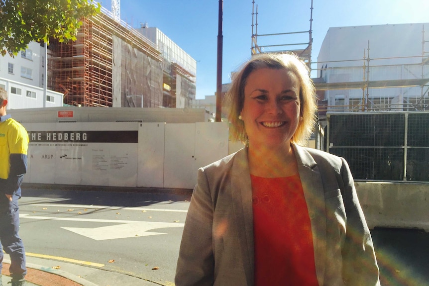 Anita Dow stands in front of  construction work in Hobart.