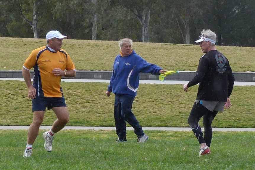 The referee uses a flag to signal at the silent touch football game held in Canberra as part of 2014 Hearing Awareness Week.