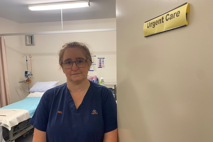 A woman in medical scrubs stands in the doorway of a surgery.