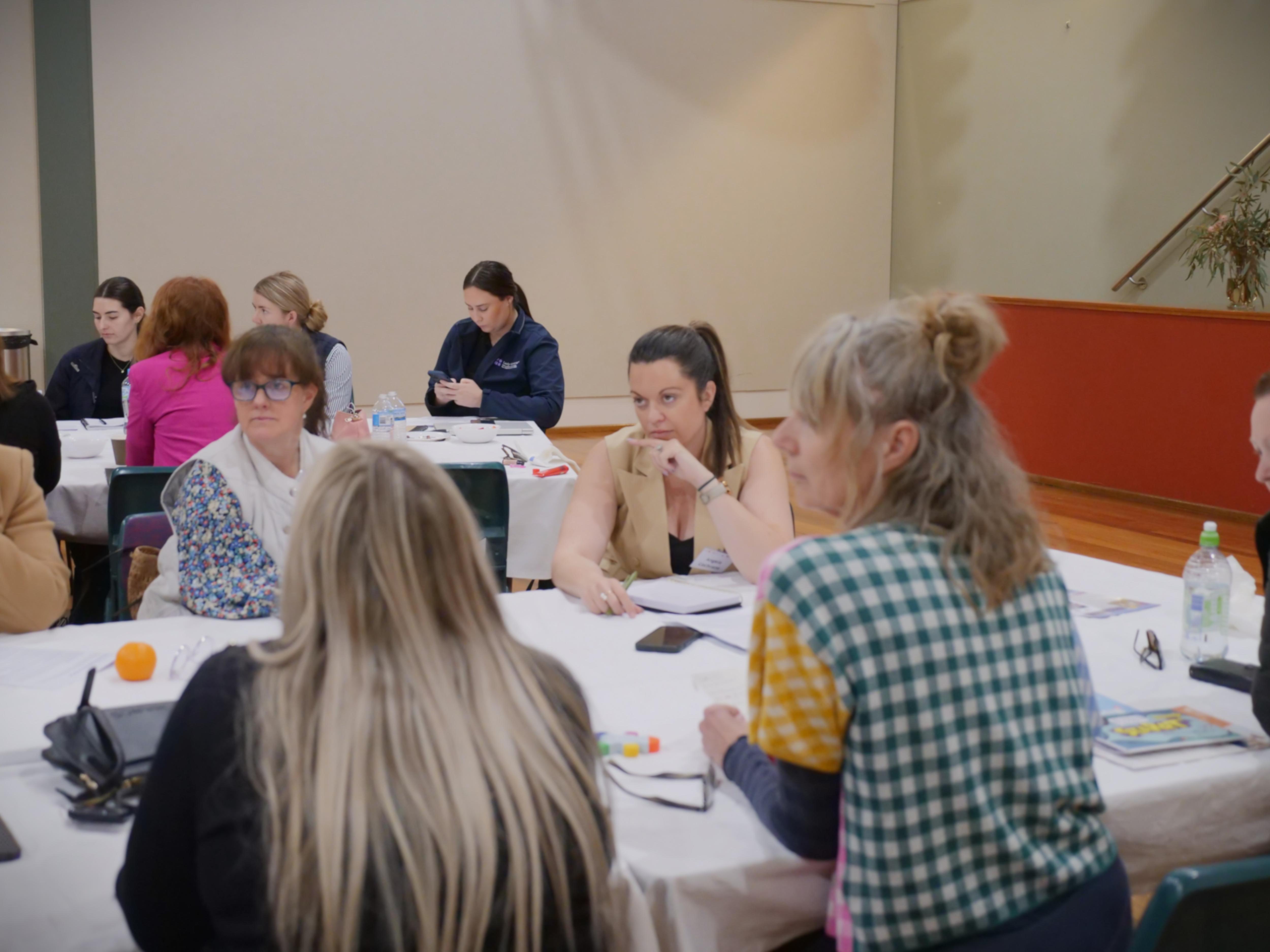 Women gather around a table to discuss childcare