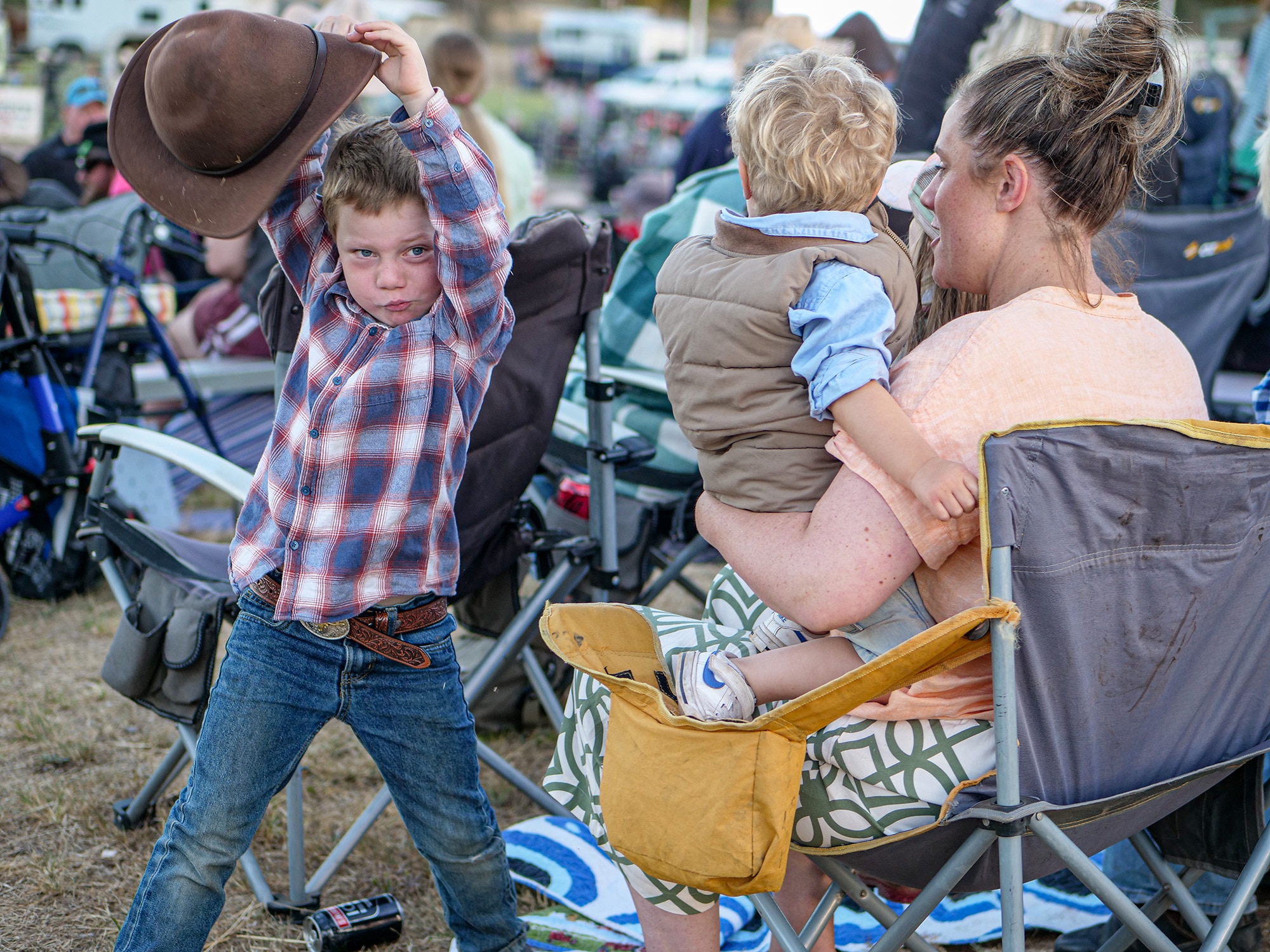 Two young boys. One is held by a woman.