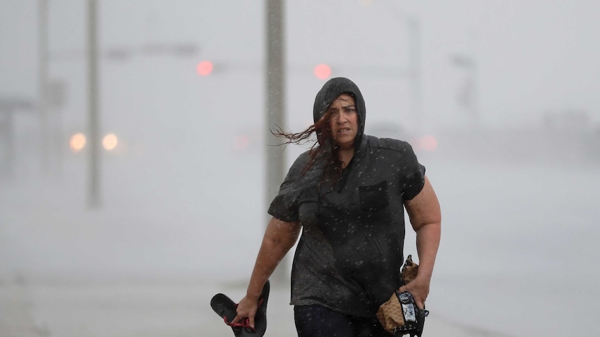 Hillary Lebeb walks through the rain along the seawall in Galveston
