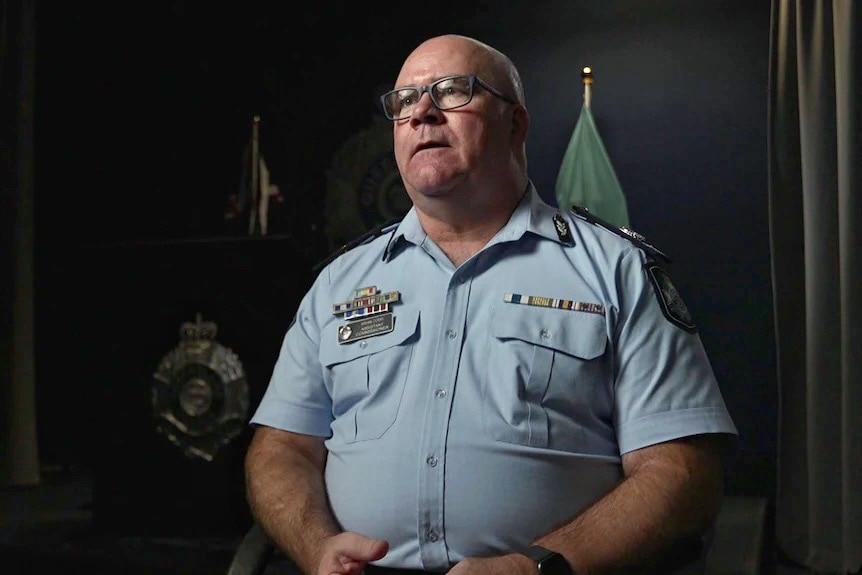 Assistant Commissioner Brian Codd seated in an interview in uniform, dark background.
