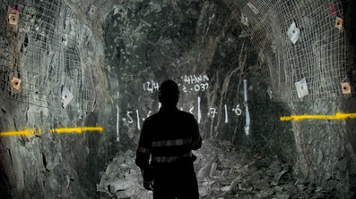 An underground miner shining a torch.