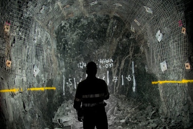An underground miner shining a torch.
