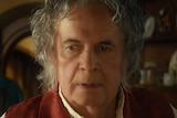 Ian Holm with long white hair looking offscreen