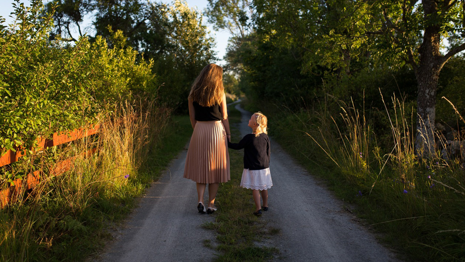 A mother and daughter go for a walk.