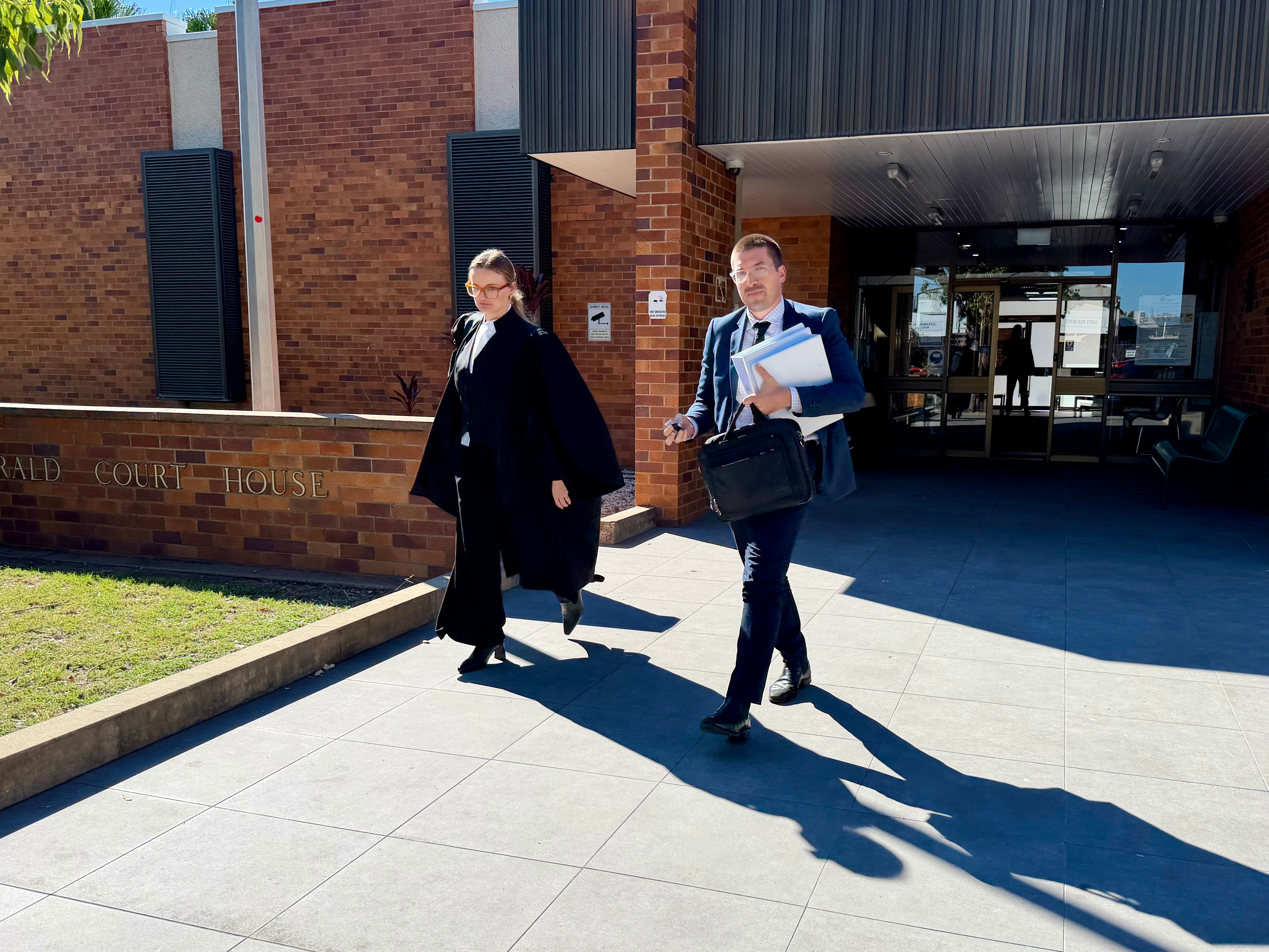 Man and woman in suit leaving courthouse with suitcases