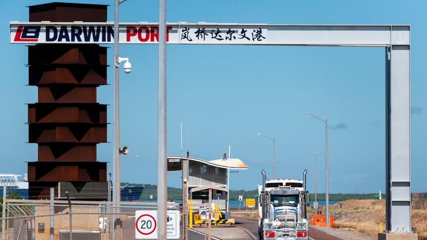 A truck drives out of the entrance of the Darwin Port on a sunny day.