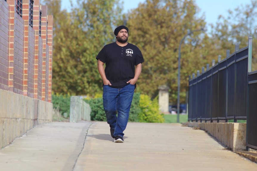 Perth musician Troy Roberts walks down a path with his hands in his pockets.