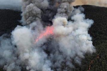 Smoke and flames rise from a bushfire.