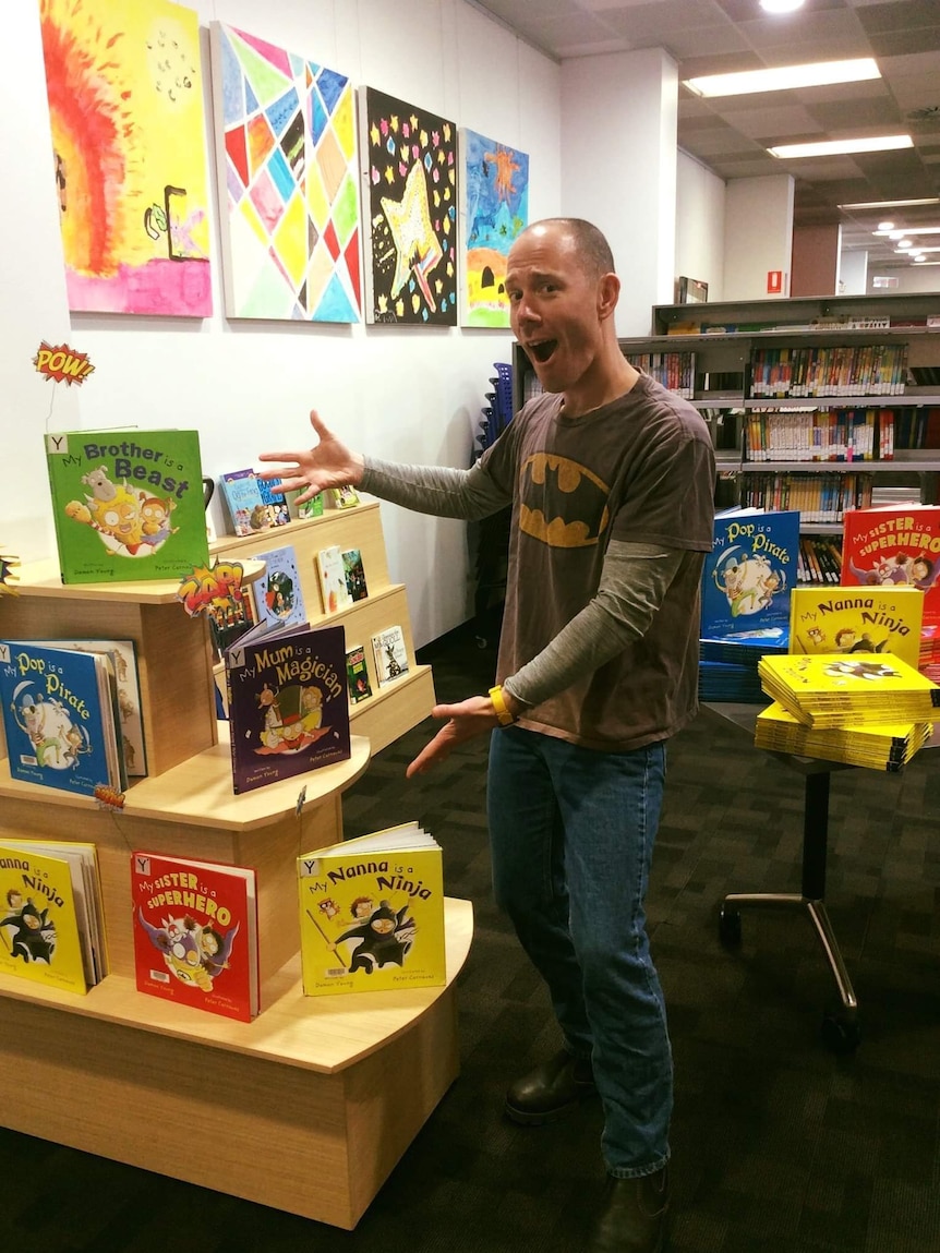 Author Damon Young in a library with his books, including My Brother Is a Beast.