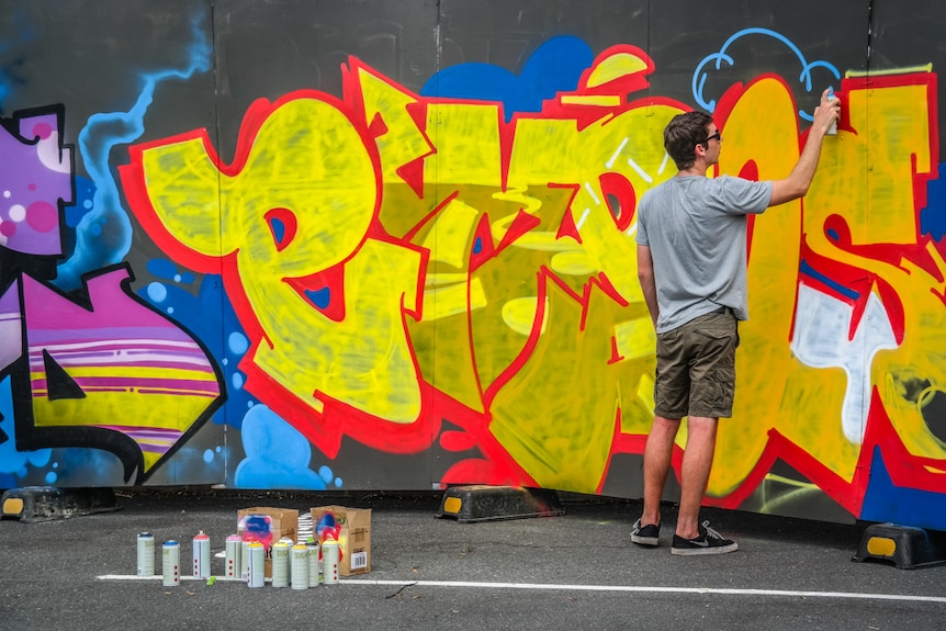 Artist Empos painting for an audience in Annerley.