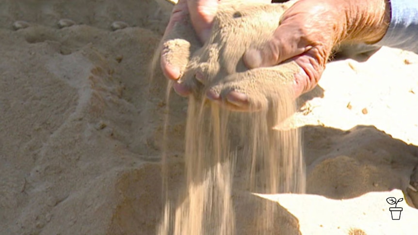 Sand poring through hands