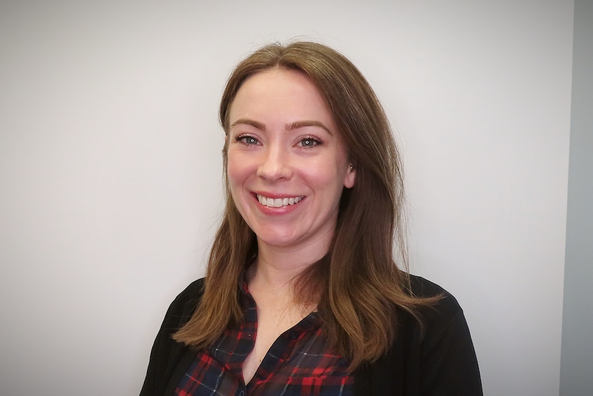 A woman with shoulder length brown hair smiles for a photo