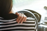 Close up woman having pain on neck and shoulder while driving car.
