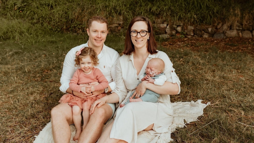 A family of four, including a baby with tubes in his nose.