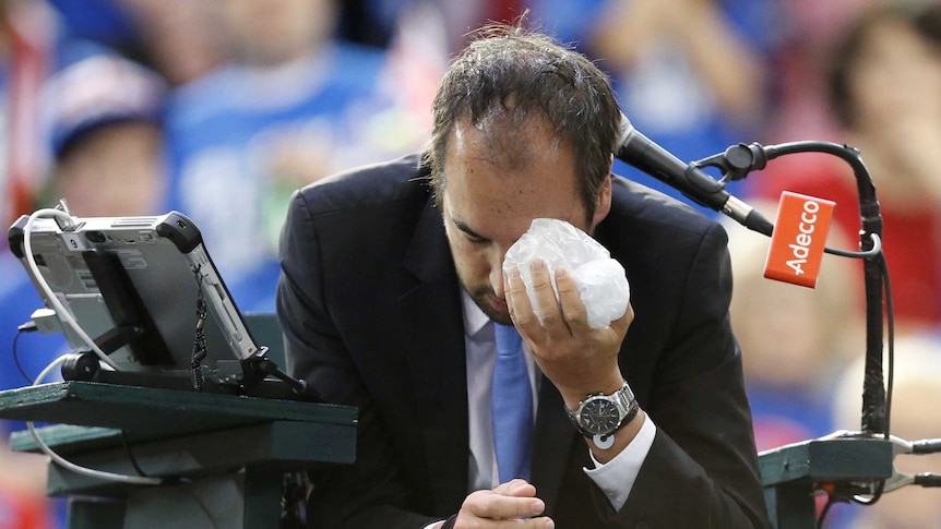 Umpire Arnaud Gabas ices his eye after being struck by a rogue ball at the Davis Cup in Ottawa