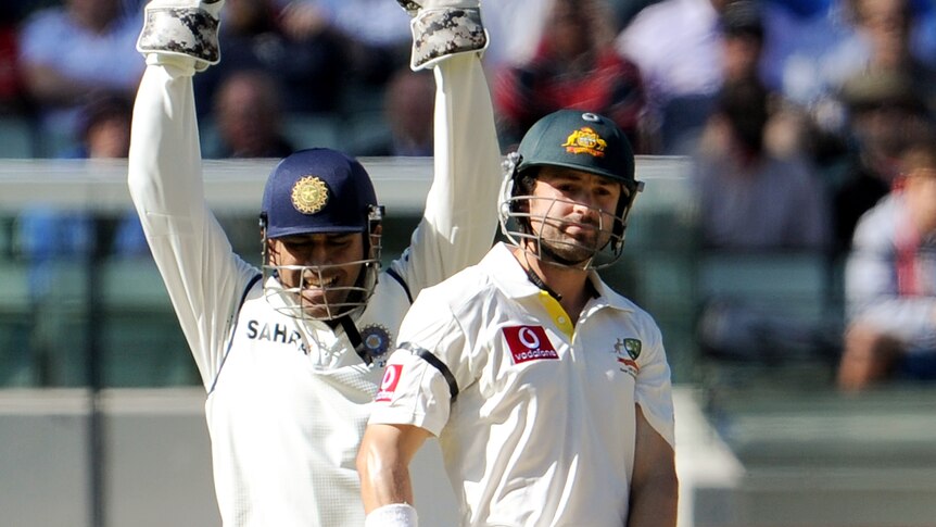 Indian wicketkeeper MS Dhoni (L) appeals successfully for a caught behind decision against Australia's Ed Cowan (R).