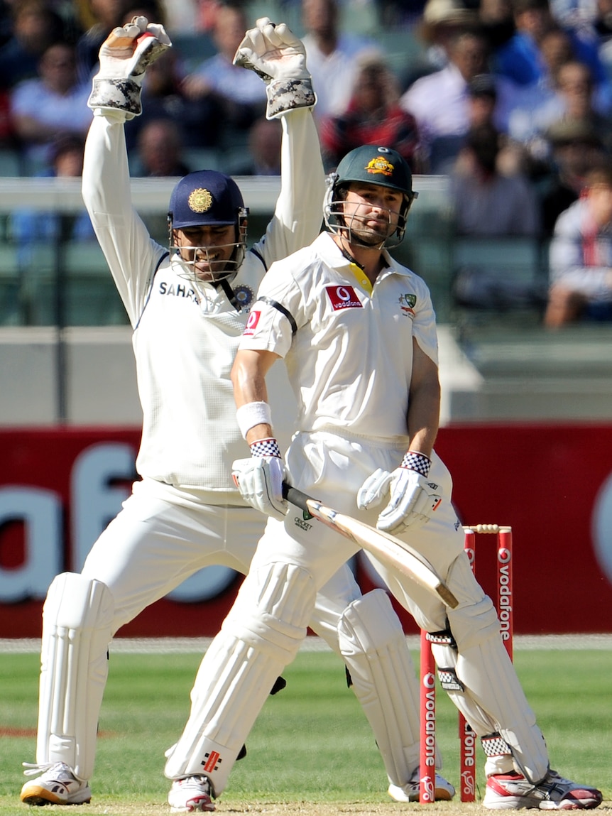 Indian wicketkeeper MS Dhoni (L) appeals successfully for a caught behind decision against Australia's Ed Cowan (R).