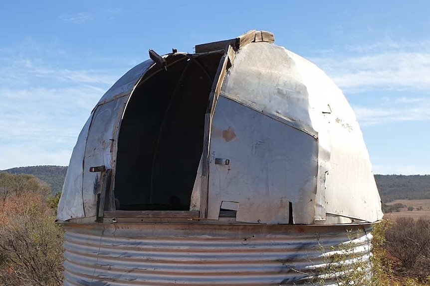 A tin dome on top of a round cylinder, form an observatory in the middle of the outback.