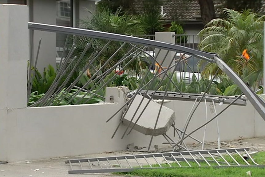 The fence of a house is damaged after a light plane crashes into a residential street in Mordialloc.