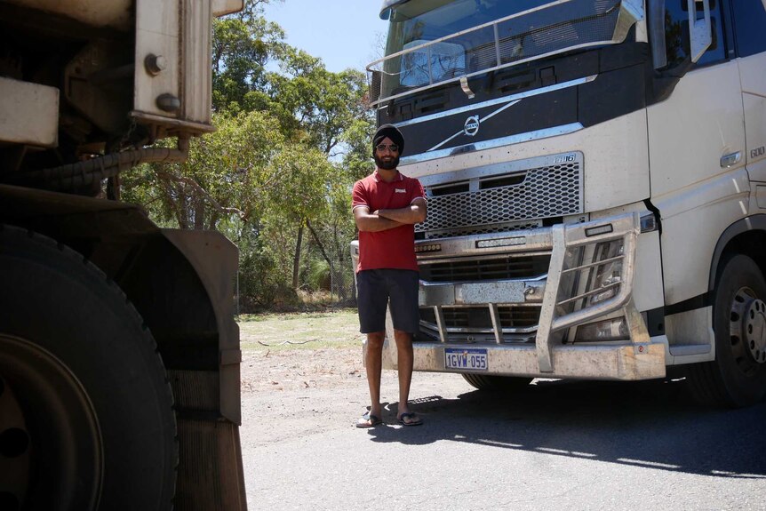Hardeep Mander stands in front of a heavy vehicle.