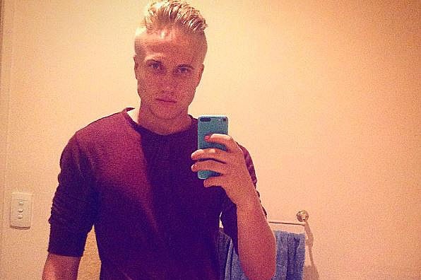 Trent Thorburn poses in a mirror taking a selfie on a mobile phone