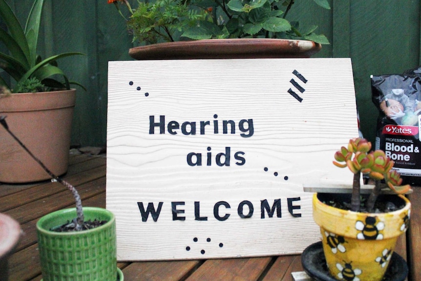 A sign reads 'hearing aids welcome'.