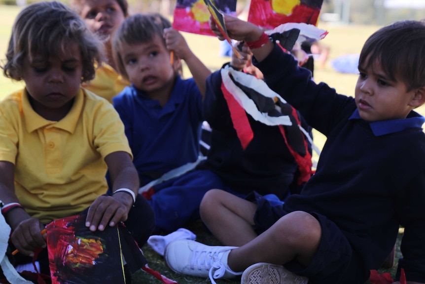 Kids hold handmade Aboriginal and Torres Strait Islander flags