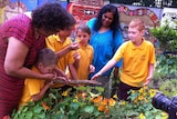 Kathryn Dodd Farrawell and Elder Wendy Buchanan with school students looking at plants in the garden.