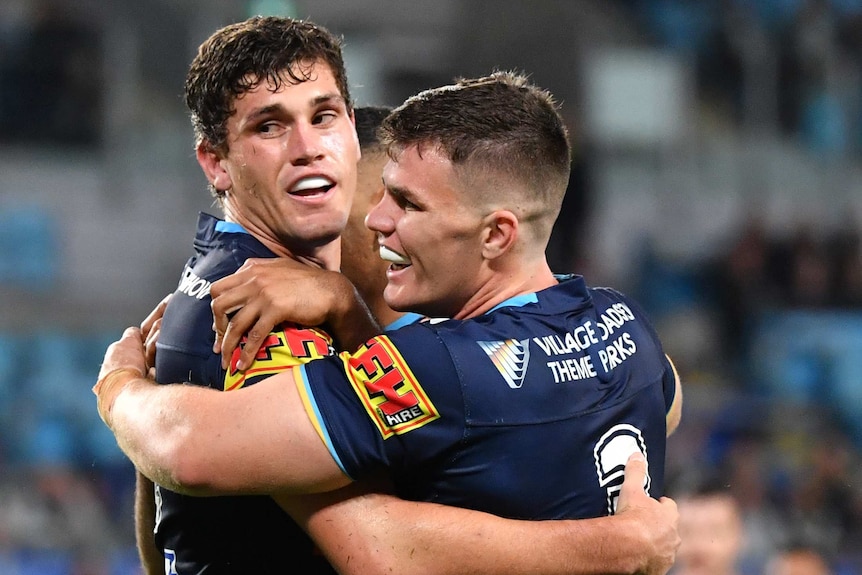 Two Gold Coast Titans players embrace as they celebrate a try against the Warriors.