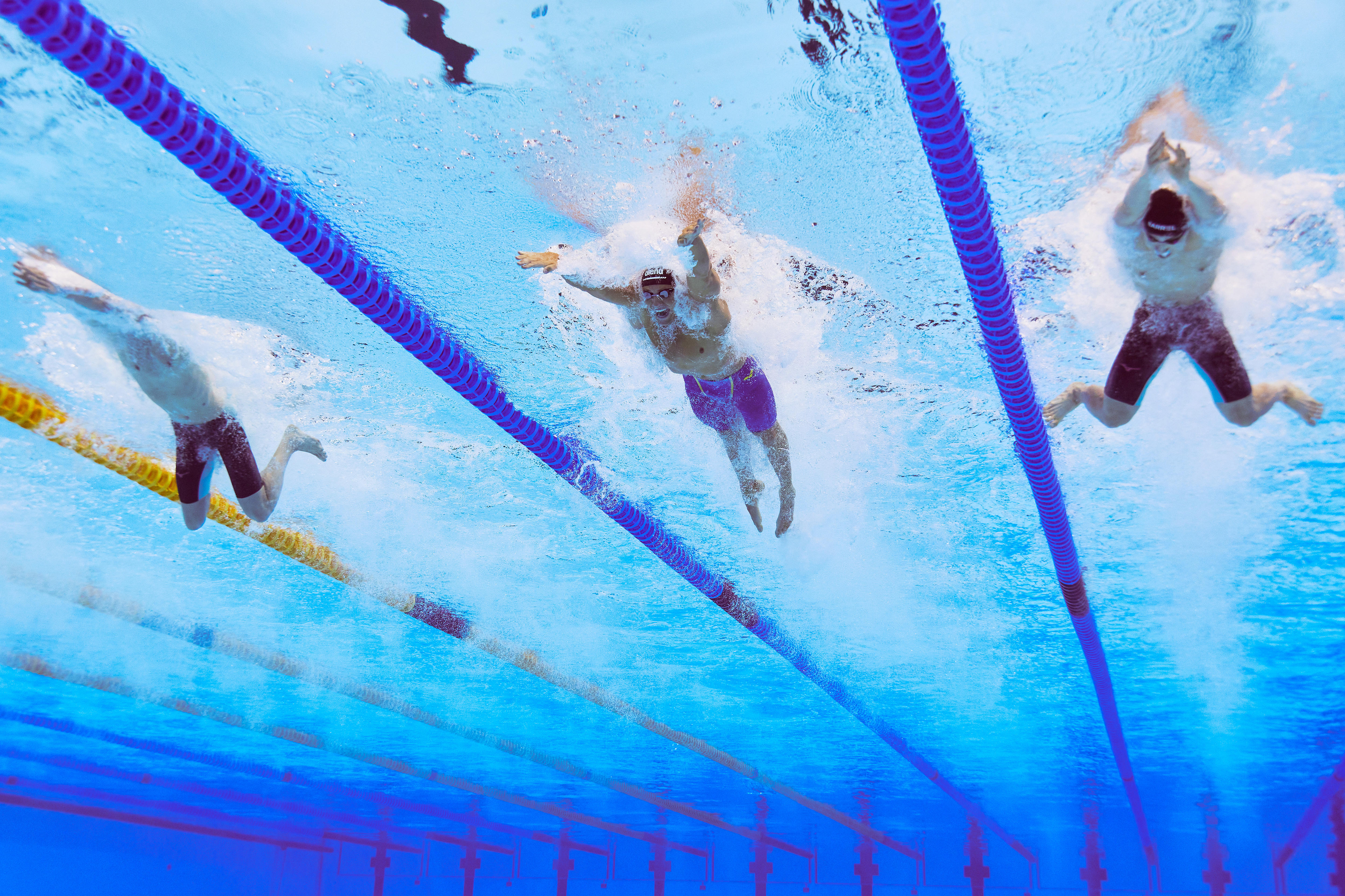 Breaststrokers swim as seen under water