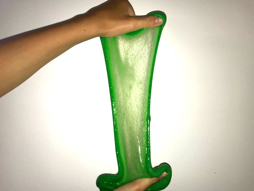 Green slime stretched between two hands
